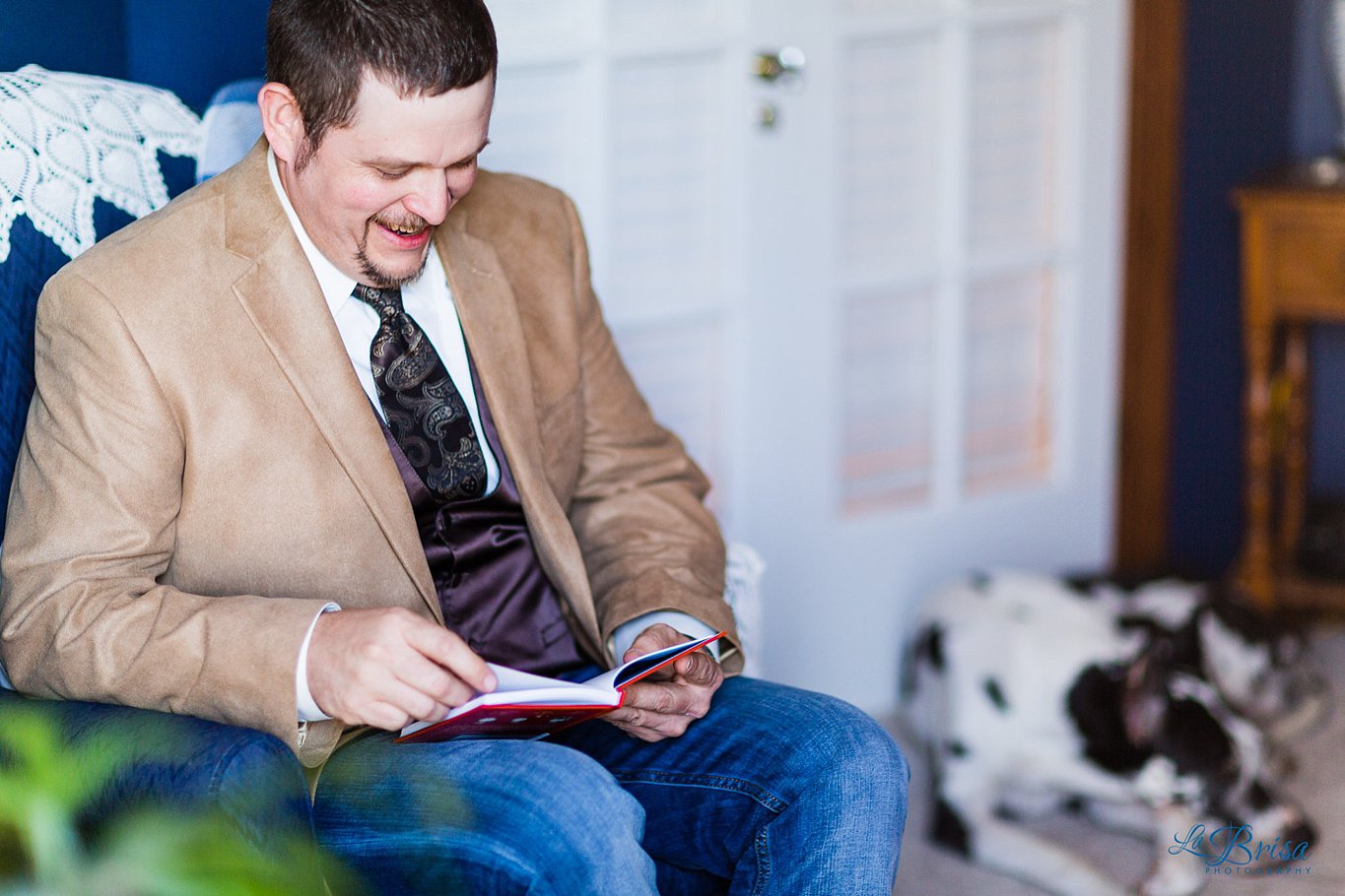 Groom reading card with dog in background