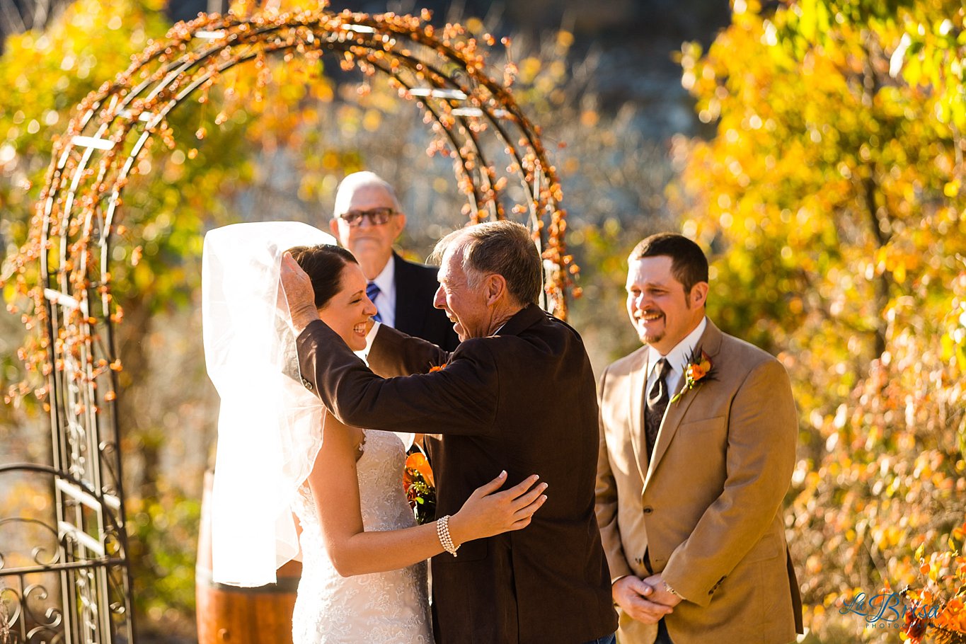 father lifting daughter's veil outdoor fall wedding