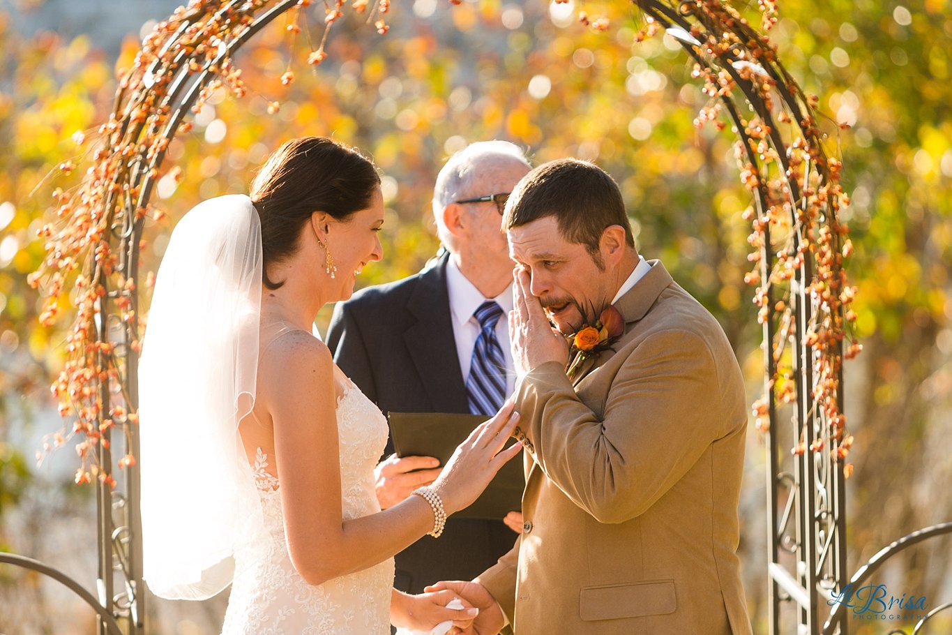 crying groom with bride outdoor fall ceremony