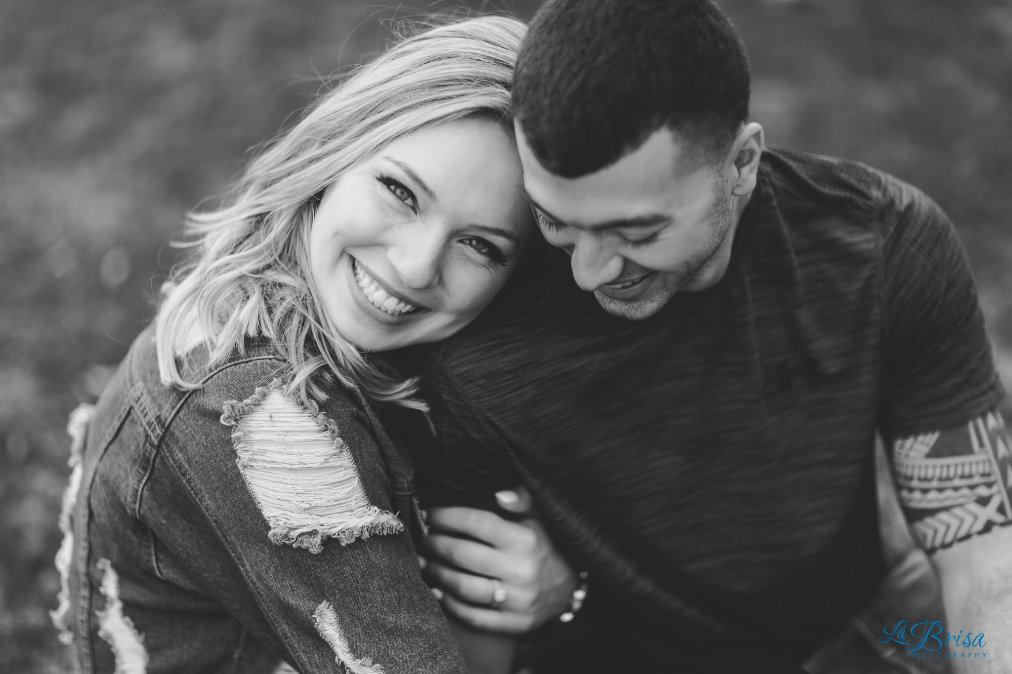 couple cuddling smiling klyde warren park engagement
